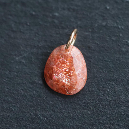 Sunstone pendant necklace in 14K gold, featuring a polished orange gemstone on a delicate chain.