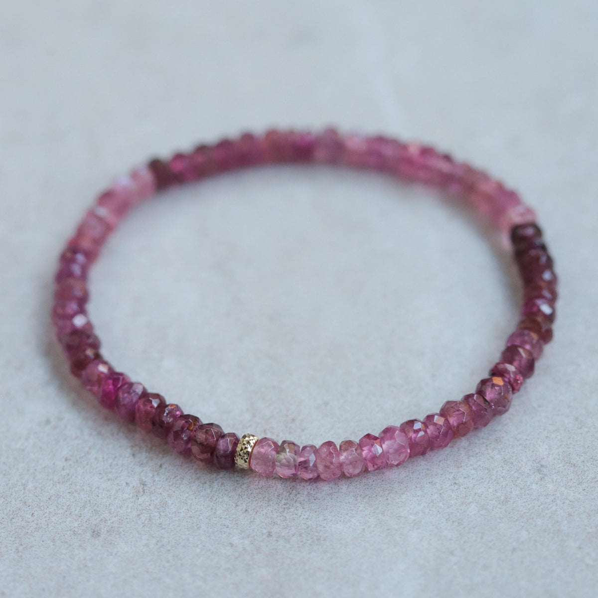 Open heart pink tourmaline bracelet with 14K gold setting from Earthly Abundance, featuring pink gemstone beads and heart-shaped charm.