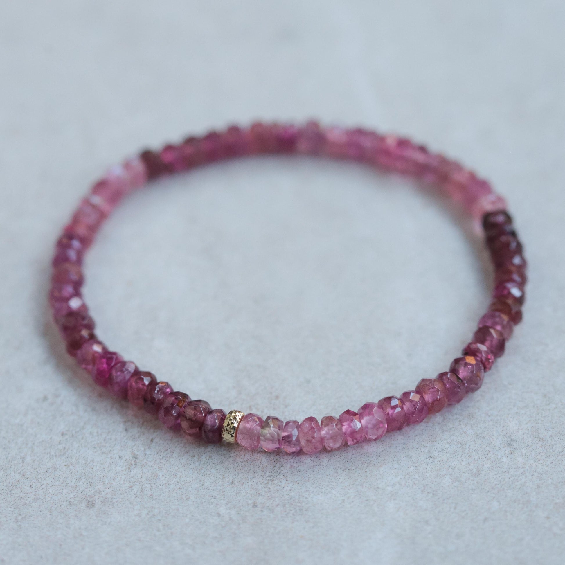 Open heart pink tourmaline bracelet with 14K gold setting from Earthly Abundance, featuring pink gemstone beads and heart-shaped charm.