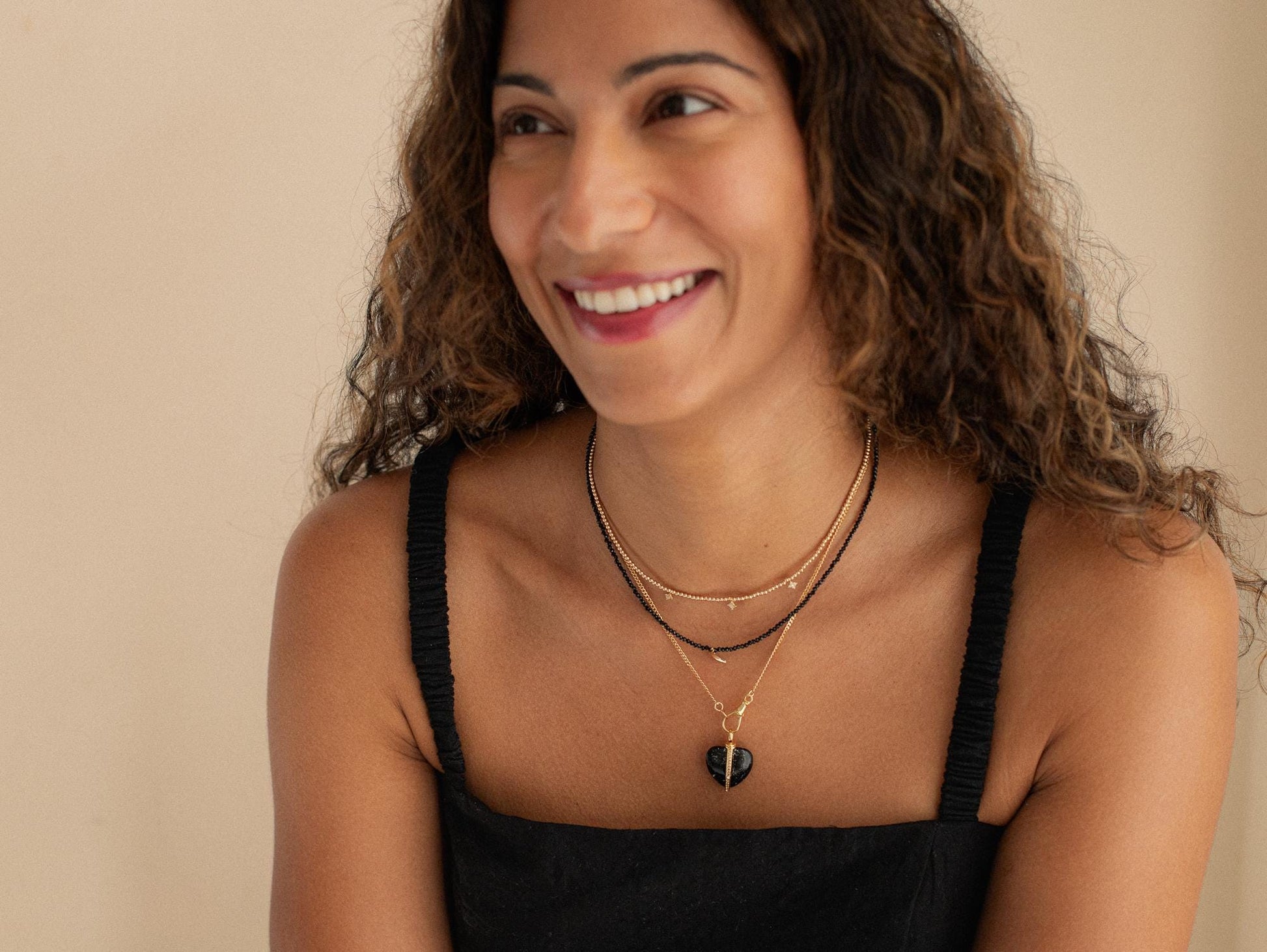 Black spinel moon necklace with 14K gold chain from Earthly Abundance, featuring a moon-shaped pendant with black gemstone details.