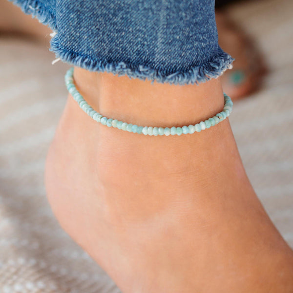 Larimar anklet with blue gemstone beads and silver clasp, handcrafted by Earthly Abundance, displayed on a white background.