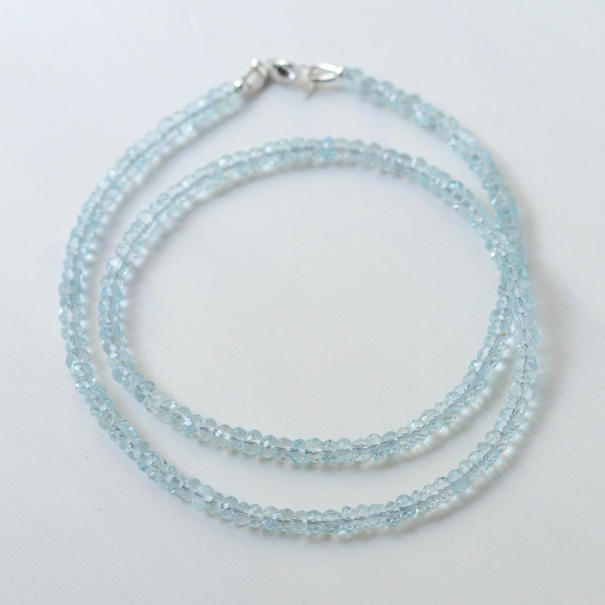 Earthly Abundance aquamarine choker necklace featuring a vibrant blue gemstone pendant on a delicate chain.