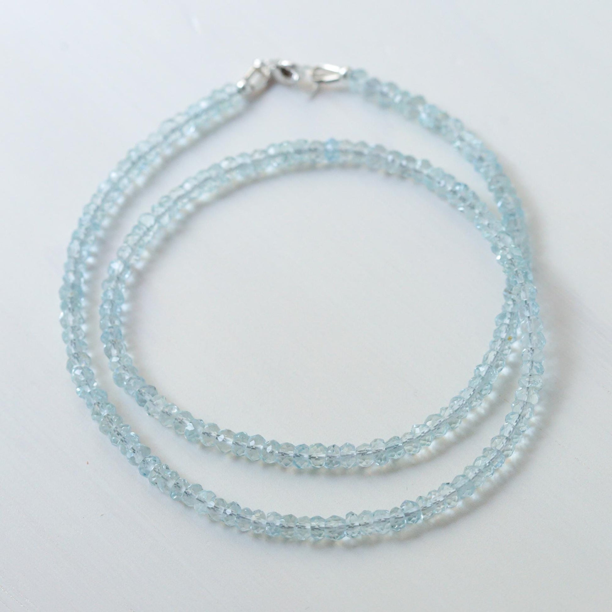 Earthly Abundance aquamarine choker necklace featuring a vibrant blue gemstone pendant on a delicate chain.
