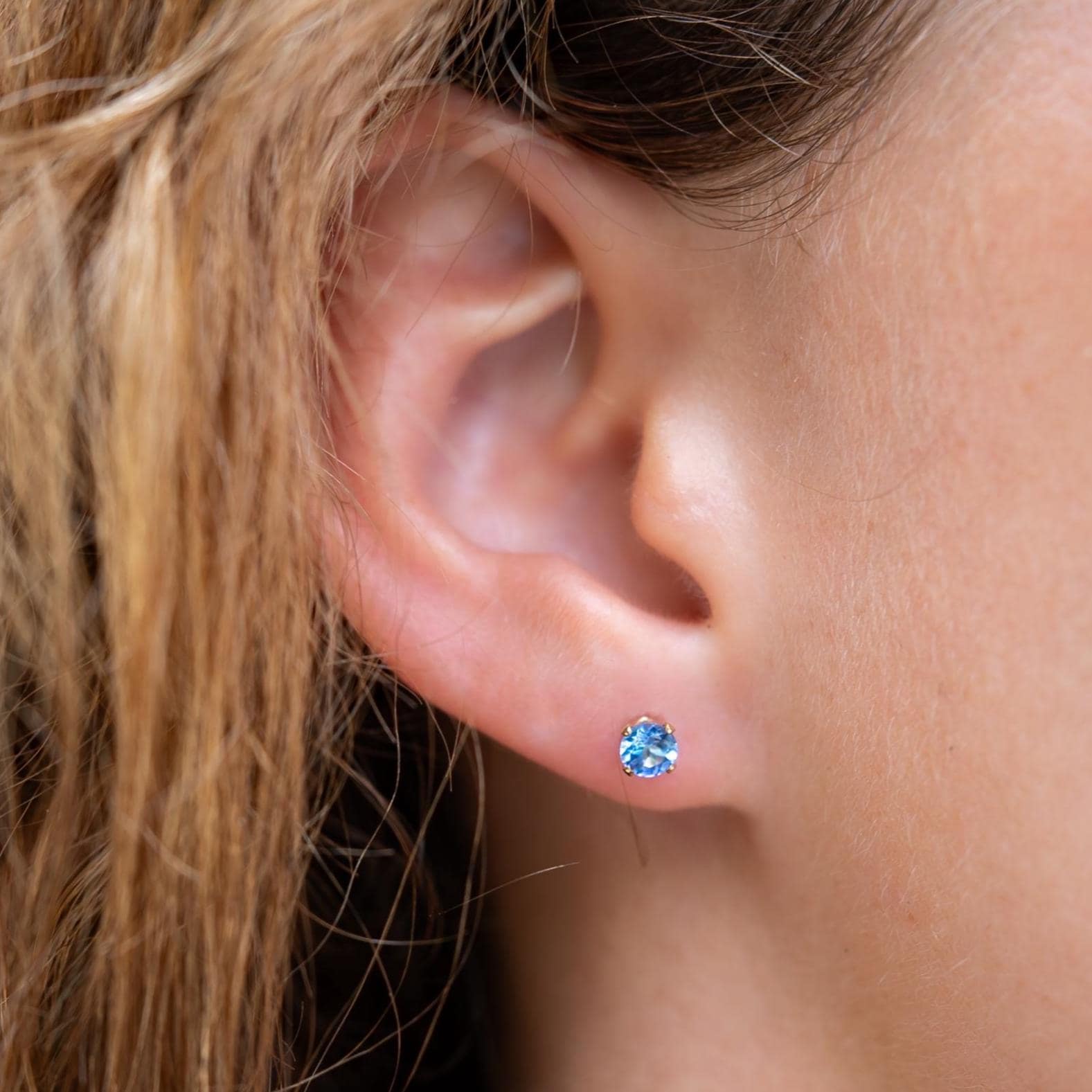 Earthly Abundance tanzanite stud earrings featuring sparkling violet-blue gemstones on silver posts.