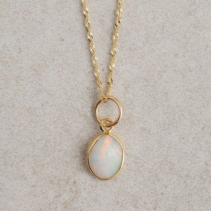 Ethiopian Opal Necklace with 14K gold chain from Earthly Abundance, featuring a vibrant, iridescent opal pendant on a delicate chain.