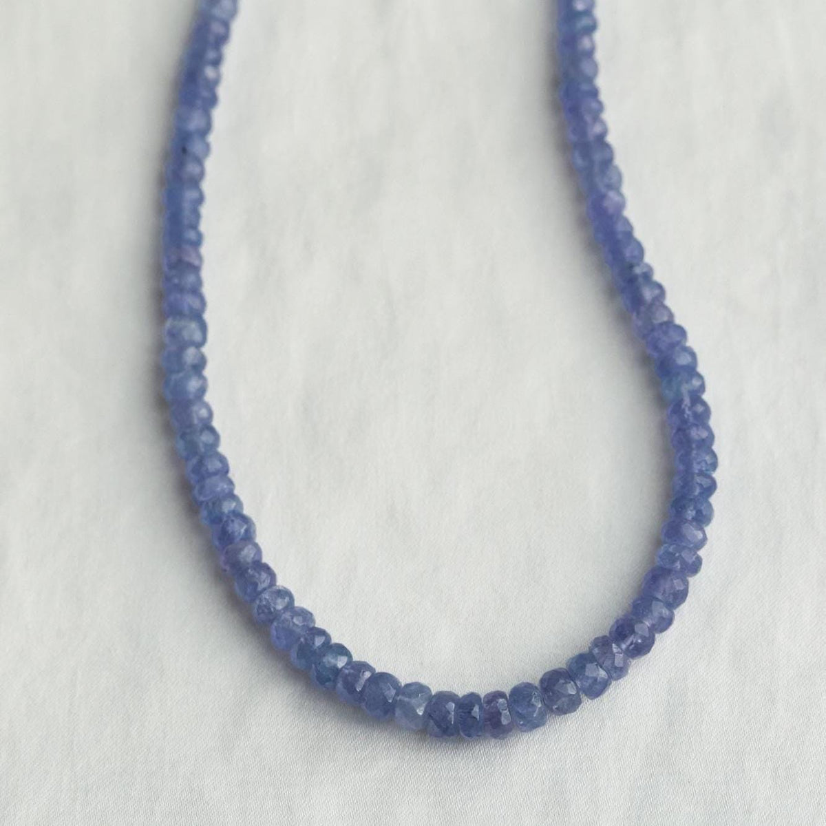 Indigo Muse Tanzanite Necklace featuring deep blue and violet tanzanite gemstones on a silver chain, by Earthly Abundance Jewelry.