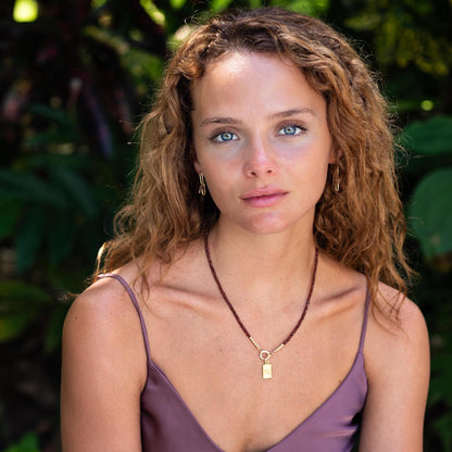 Earthly Abundance Amor Garnet Necklace featuring a deep red garnet gemstone pendant on a silver chain.