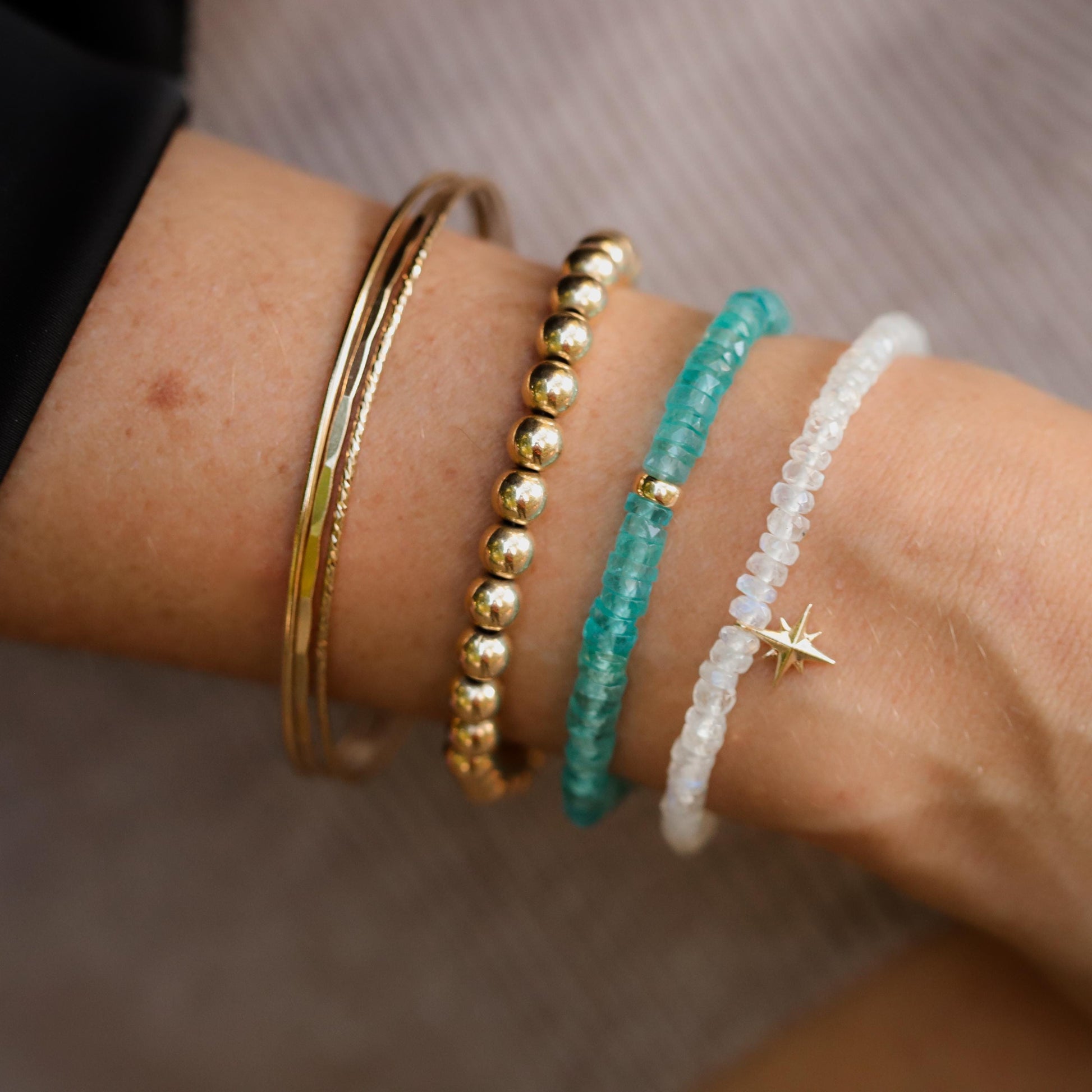 Earthly Abundance Apatite Heishi bracelet with small blue-green gemstone beads on a stretch cord.