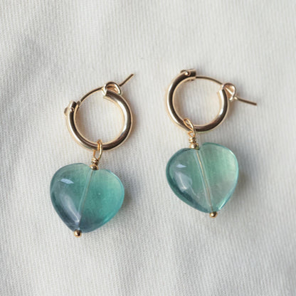 Earthly Abundance fluorite heart hoop earrings featuring vibrant green and purple fluorite stones set in silver hoops.