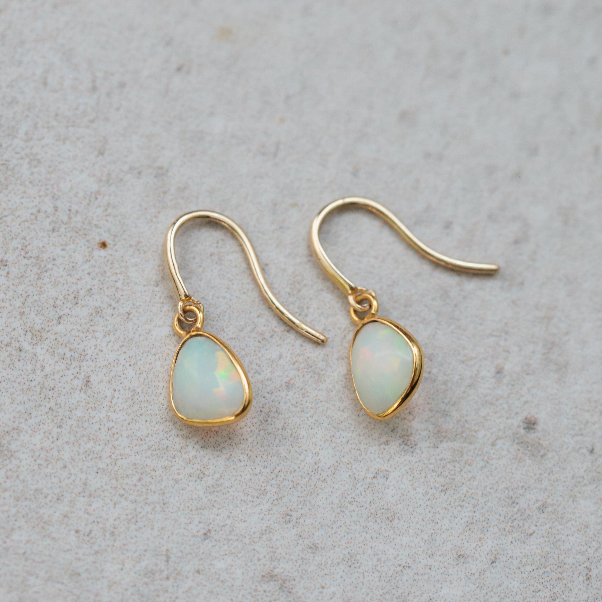 Ethiopian Opal earrings in 14K gold with elegant, effortless design featuring vibrant, iridescent opals and gold hooks.