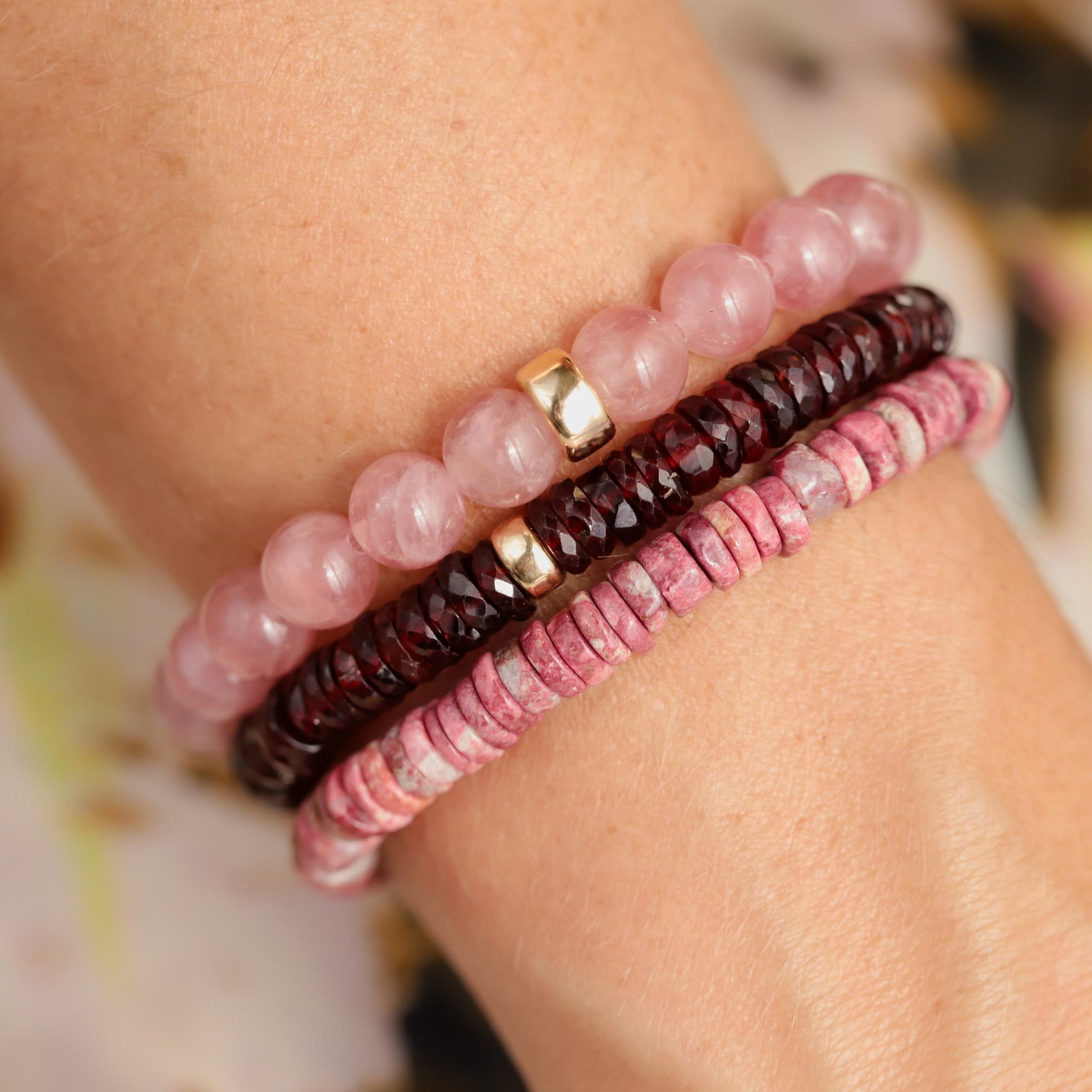 Earthly Abundance garnet Heishi bracelet with small red gemstone beads and elastic band, close-up view of the jewelry.
