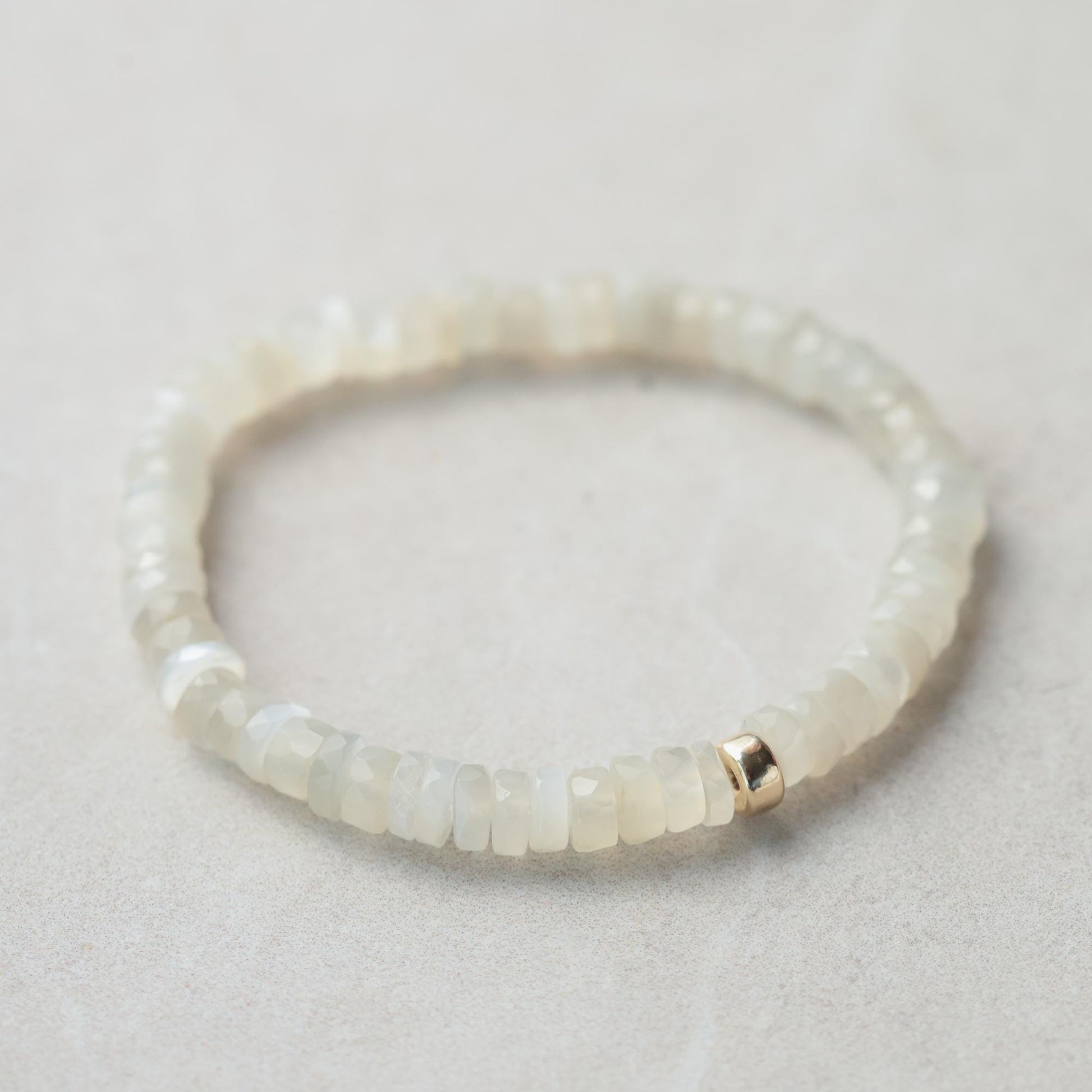 Soft glow moonstone heishi bracelet featuring smooth, round moonstone beads on a delicate elastic band, crafted by Earthly Abundance.