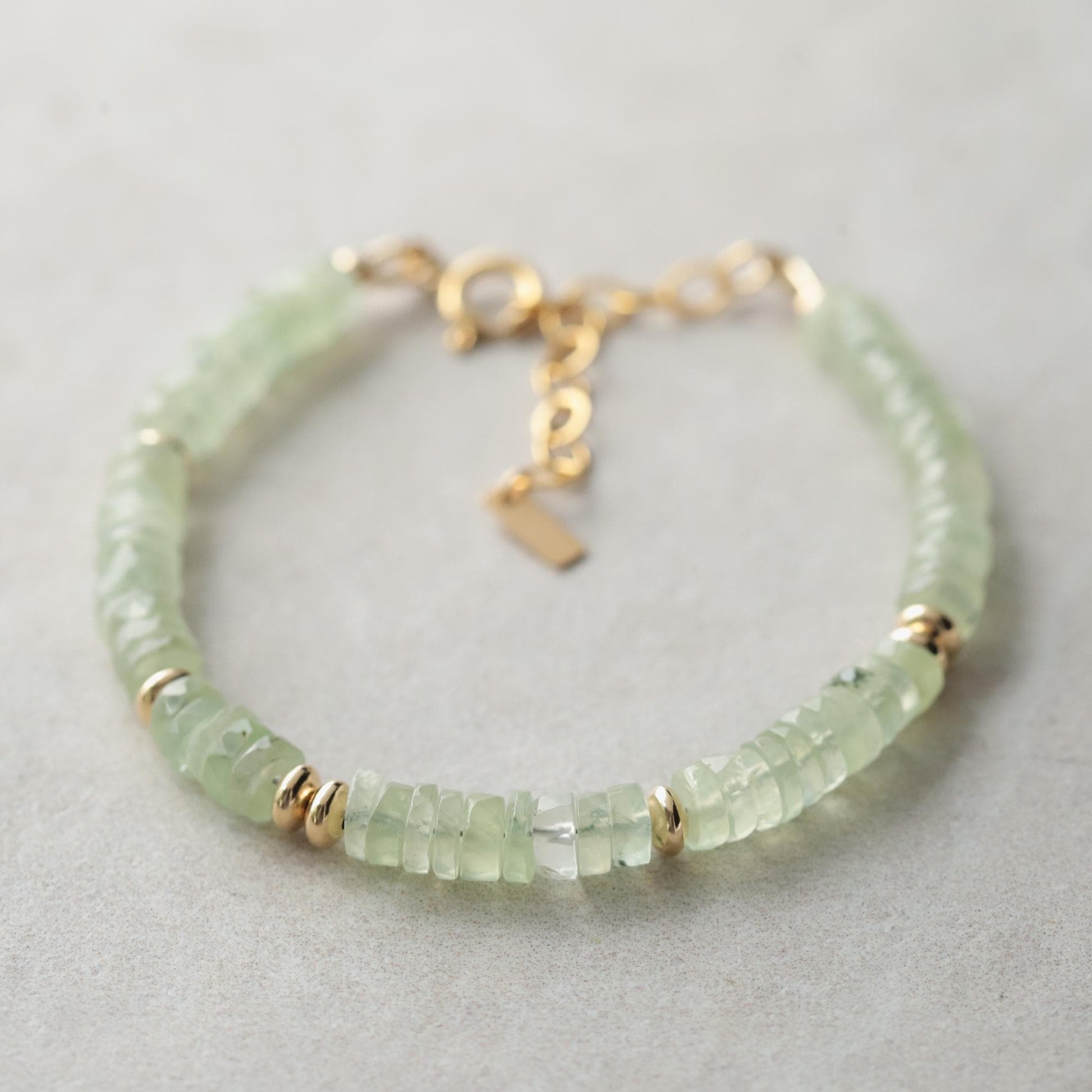 Prehnite Glow bracelet featuring smooth green gemstones on an elastic band, designed by Earthly Abundance.