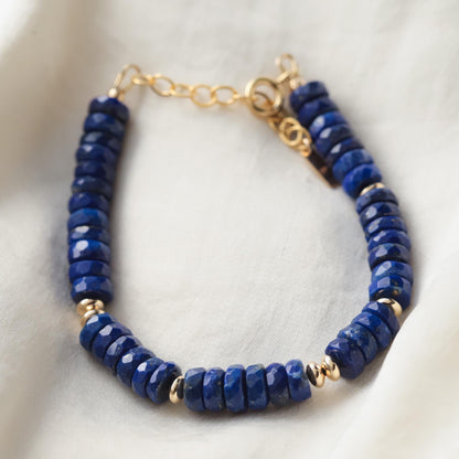 Deep blue lapis lazuli bracelet with polished round beads from Earthly Abundance, showcasing vibrant blue stones with gold-toned accents.