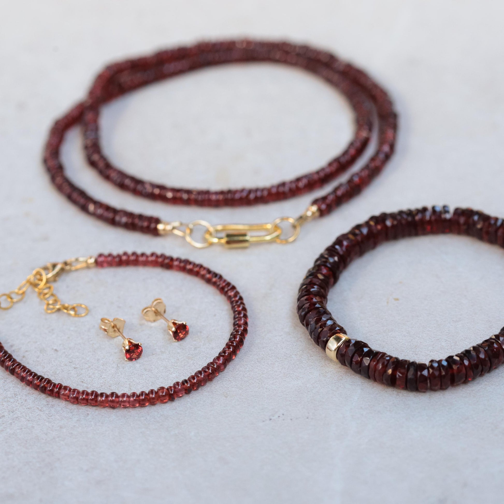 Earthly Abundance garnet Heishi bracelet with small red garnet beads on a delicate elastic cord.