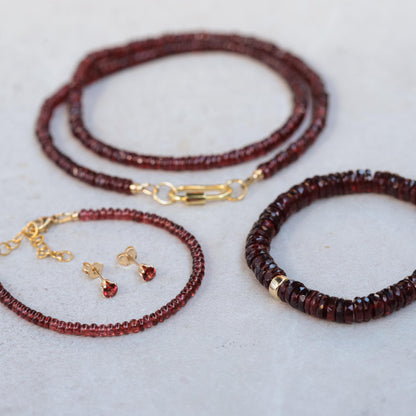 Earthly Abundance garnet Heishi bracelet with small red garnet beads on a delicate elastic cord.