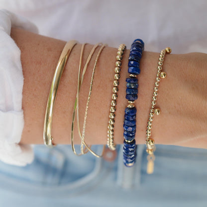 Deep Blue Beauty Lapis Lazuli bracelet featuring vibrant blue stones with gold accents, styled on a delicate wrist.