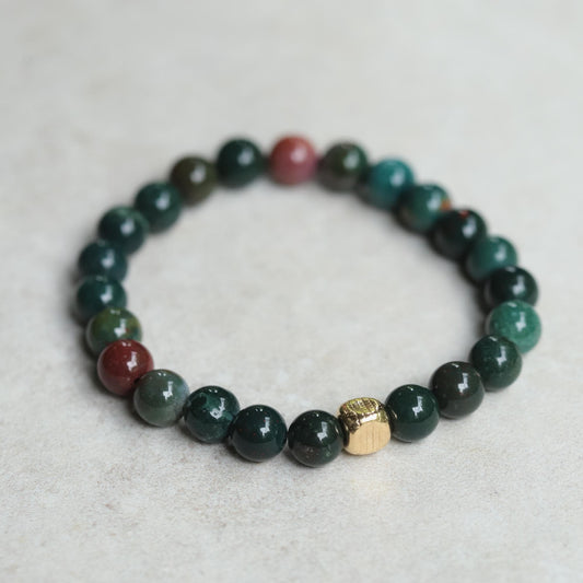 Earth Energy Bloodstone bracelet featuring polished bloodstone beads on a stretch cord, showcased in a close-up shot.