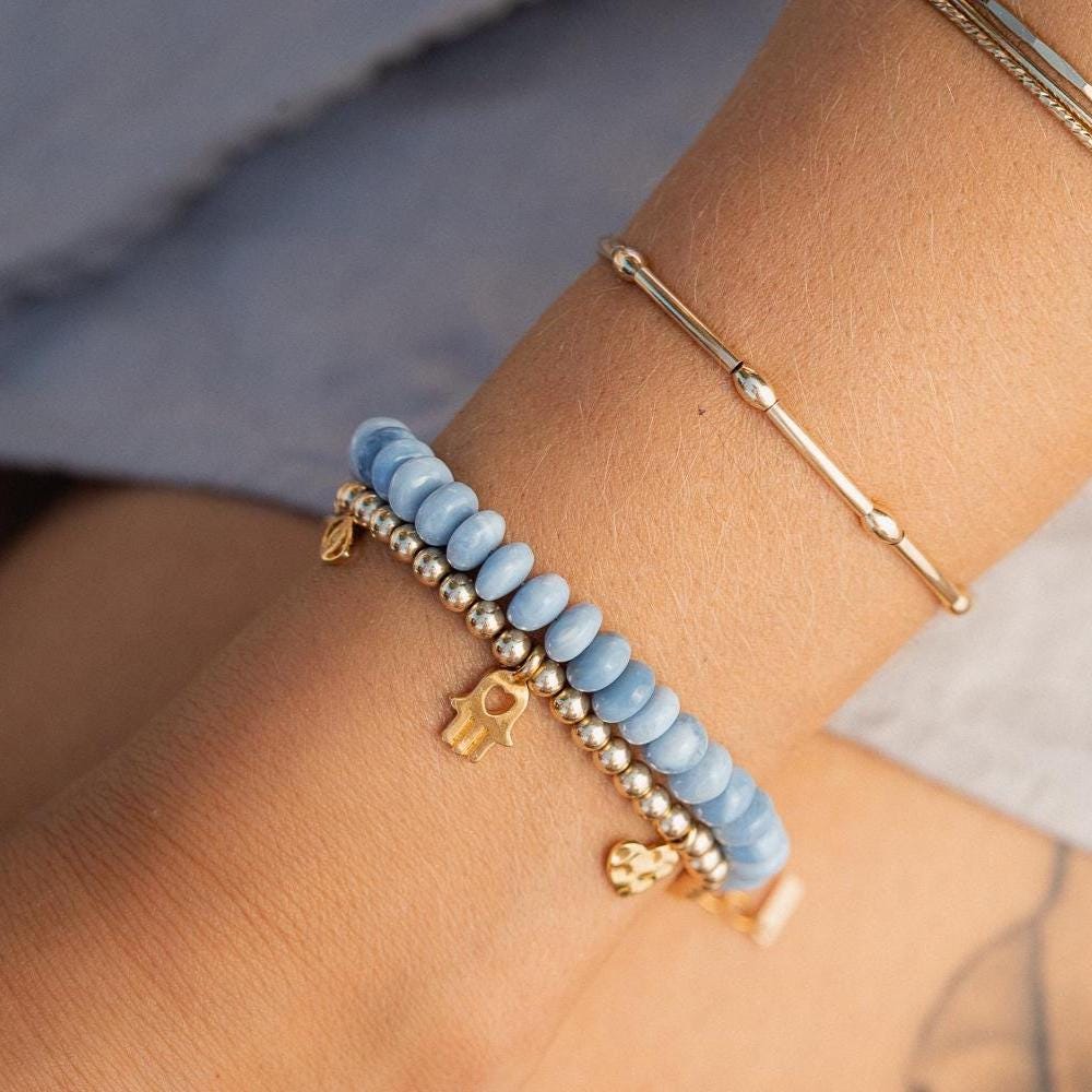 Blue opal bracelet with coastal-inspired heart charm from Earthly Abundance, featuring polished beads on a delicate elastic band.