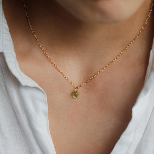 14K Peridot pendant necklace by Earthly Abundance featuring a vibrant green gemstone on a delicate chain.