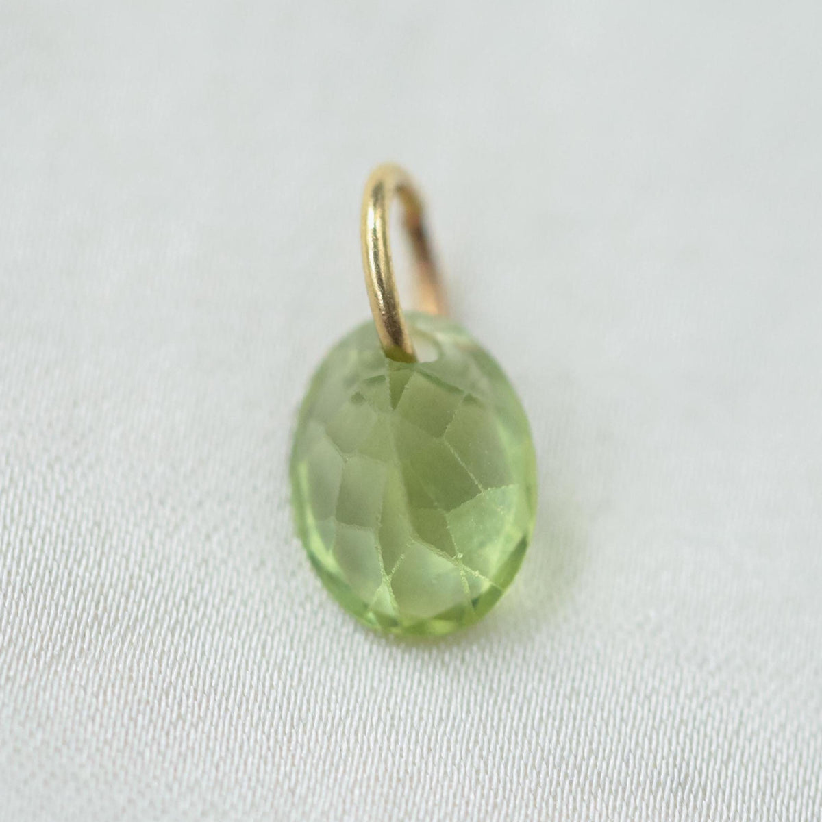 14K Peridot pendant necklace featuring a vibrant green gemstone, displayed on a delicate chain.