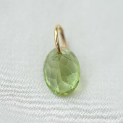 14K Peridot pendant necklace featuring a vibrant green gemstone, displayed on a delicate chain.