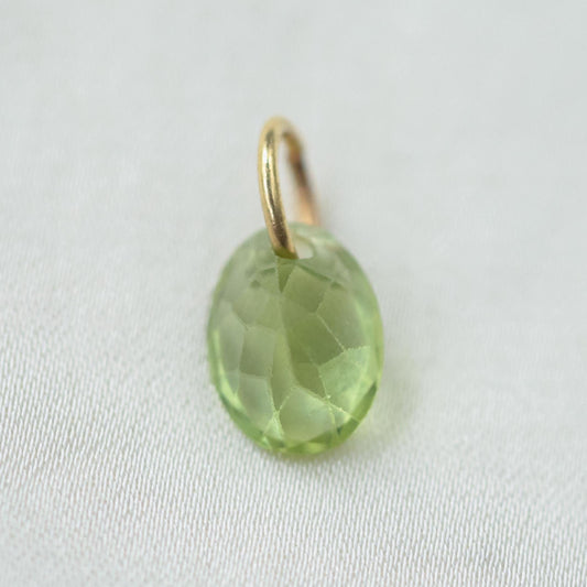 14K Peridot pendant necklace featuring a vibrant green gemstone, displayed on a delicate chain.