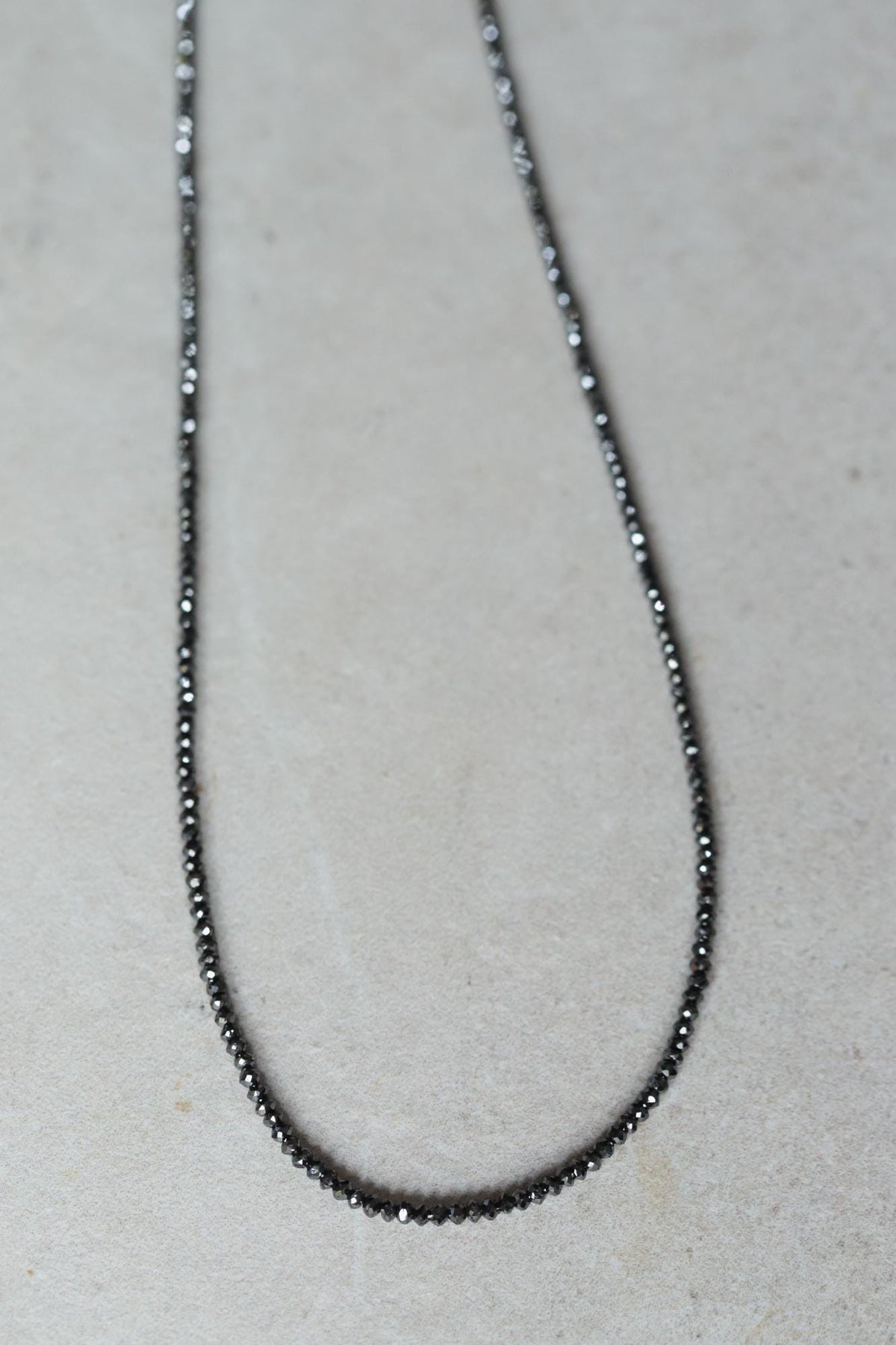 Unique black diamond necklace by Earthly Abundance featuring a single striking black diamond pendant on a delicate chain.
