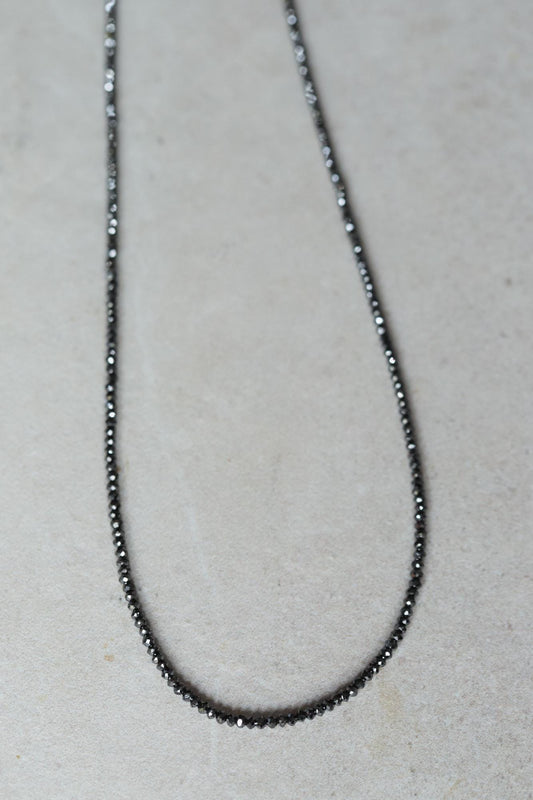 Unique black diamond necklace by Earthly Abundance featuring a single striking black diamond pendant on a delicate chain.
