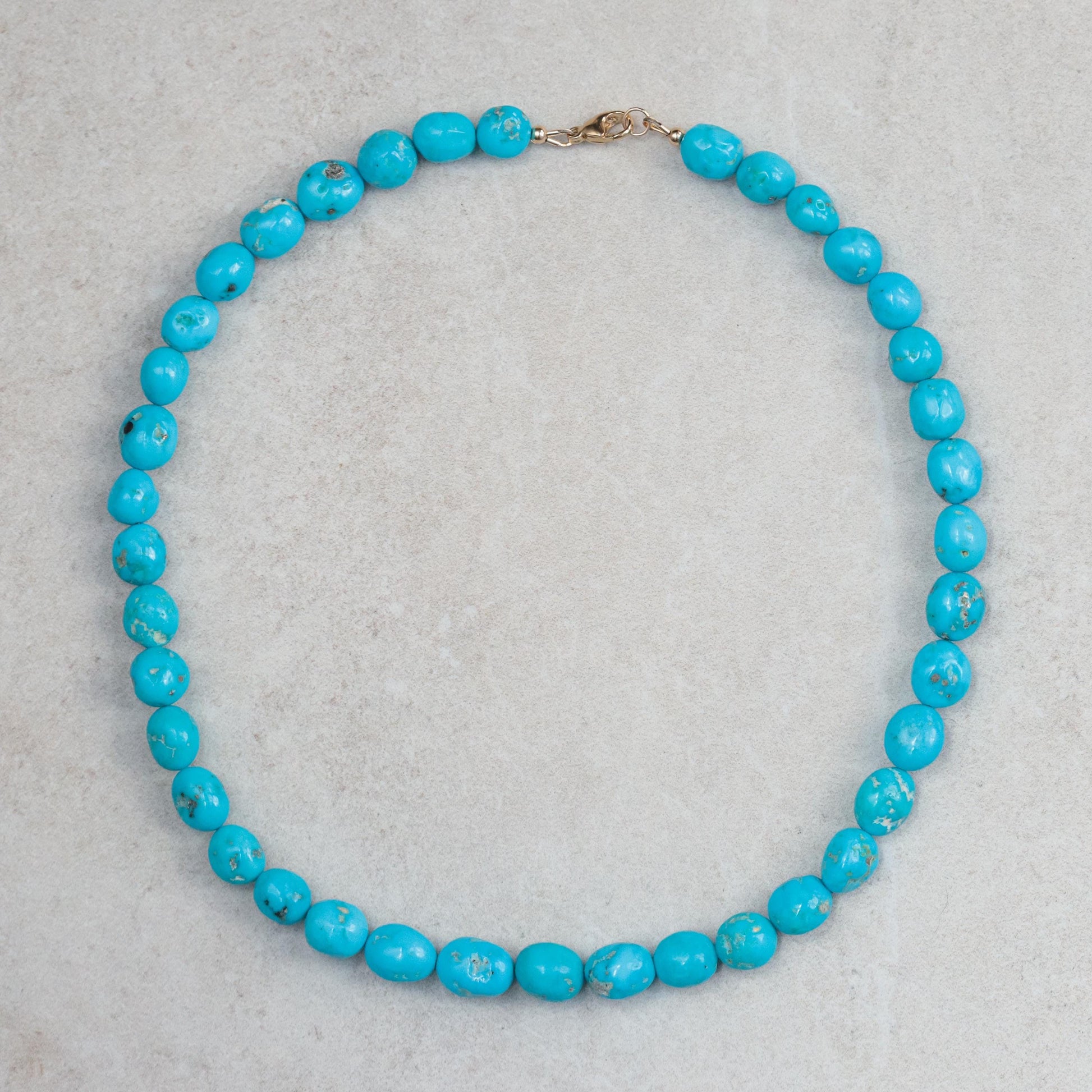 14K Sleeping Beauty turquoise pendant by Earthly Abundance featuring a vibrant turquoise gemstone in a gold setting.