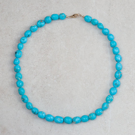 14K Sleeping Beauty turquoise pendant by Earthly Abundance featuring a vibrant turquoise gemstone in a gold setting.