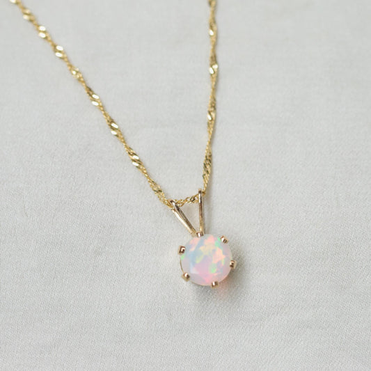 Ethiopian Opal pendant necklace featuring a vibrant, oval-shaped opal set in a 14K gold bezel on a delicate chain.