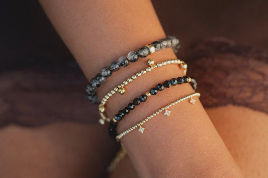 Black rutilated quartz bracelet with 6mm beads from Earthly Abundance Jewelry, showcasing polished black quartz with golden rutile inclusions.