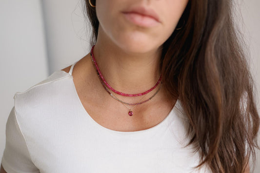 Pink tourmaline necklace pendant in 14K gold with a delicate chain, showcasing a vibrant pink gemstone on a fine jewelry chain.