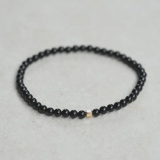 Men’s black Tourmaline cube bracelet from Earthly Abundance featuring polished black stone beads on an elastic band.