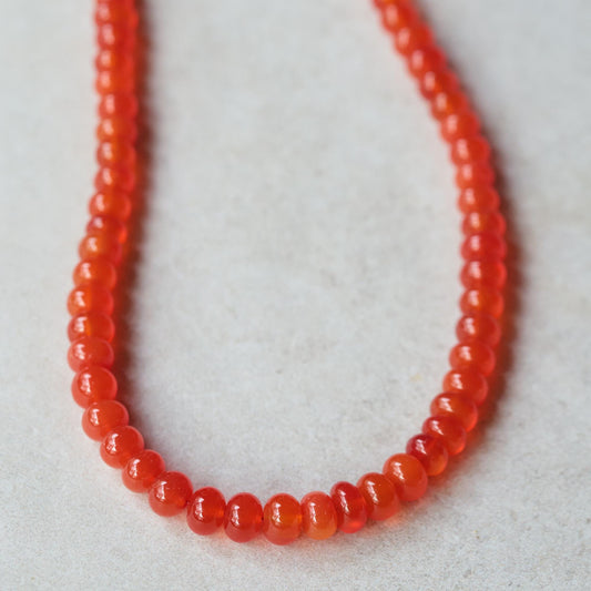 Earthly Abundance Solar Flare Carnelian Necklace featuring vibrant orange-red gemstone on a delicate chain.