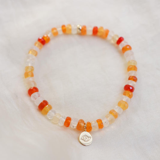 Fire Opal Evil Eye bracelet by Earthly Abundance featuring vibrant fire opal beads and an evil eye charm on a delicate bracelet.