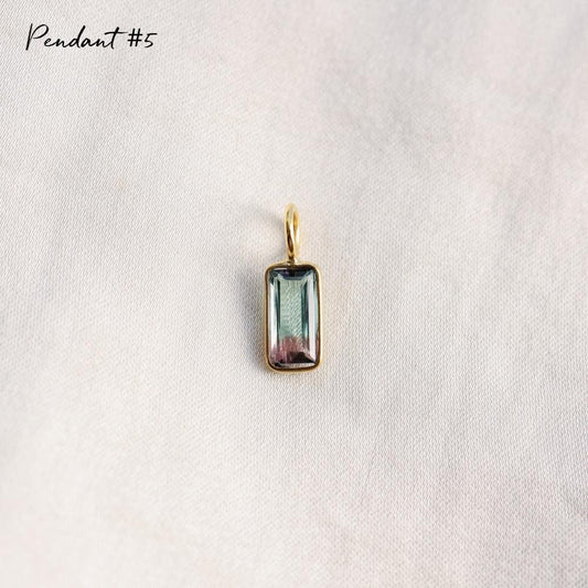 Unique bi-color tourmaline pendant with sterling silver setting, showcasing vibrant color transitions and intricate craftsmanship.