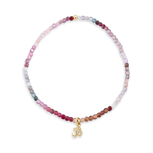 Multicolor spinel and diamond Om bracelet in solid 14K gold, featuring vibrant gemstones and intricate design.