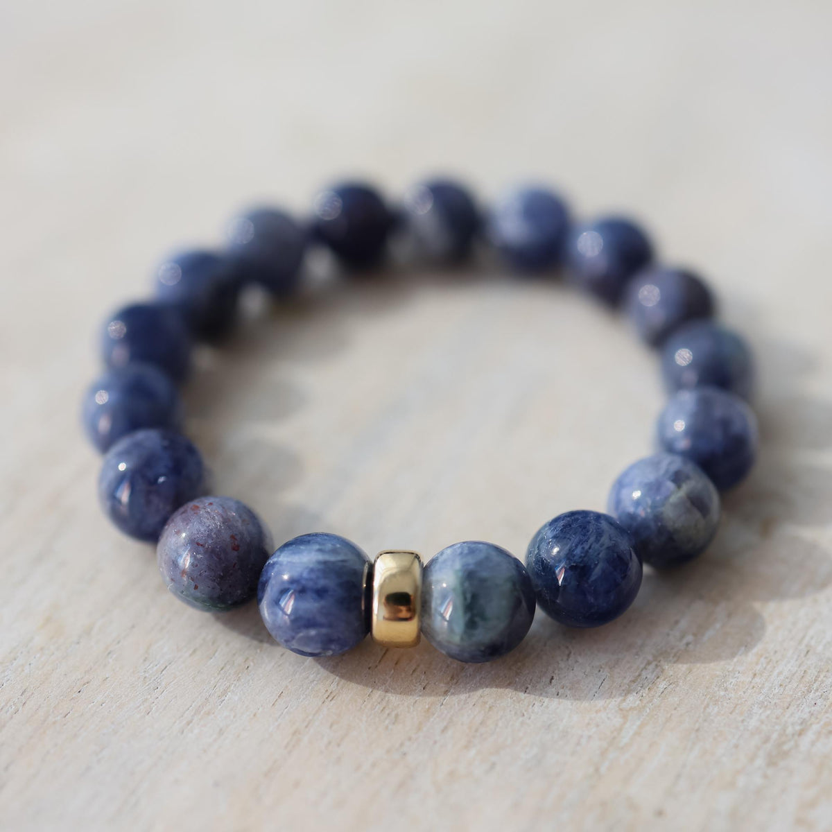 Iolite bracelet with 10mm beads from Earthly Abundance, featuring deep violet-blue stones on a flexible cord.