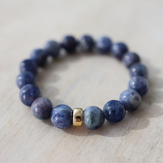 Iolite bracelet with 10mm beads from Earthly Abundance, featuring deep violet-blue stones on a flexible cord.