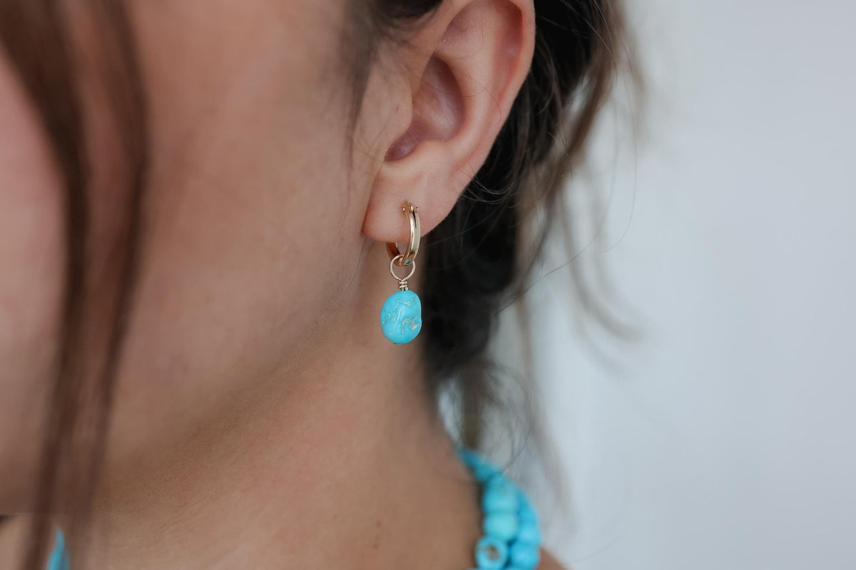 Earthly Abundance Sleeping Beauty hoops earrings featuring vibrant pink and orange gemstones on gold-tone hoops.
