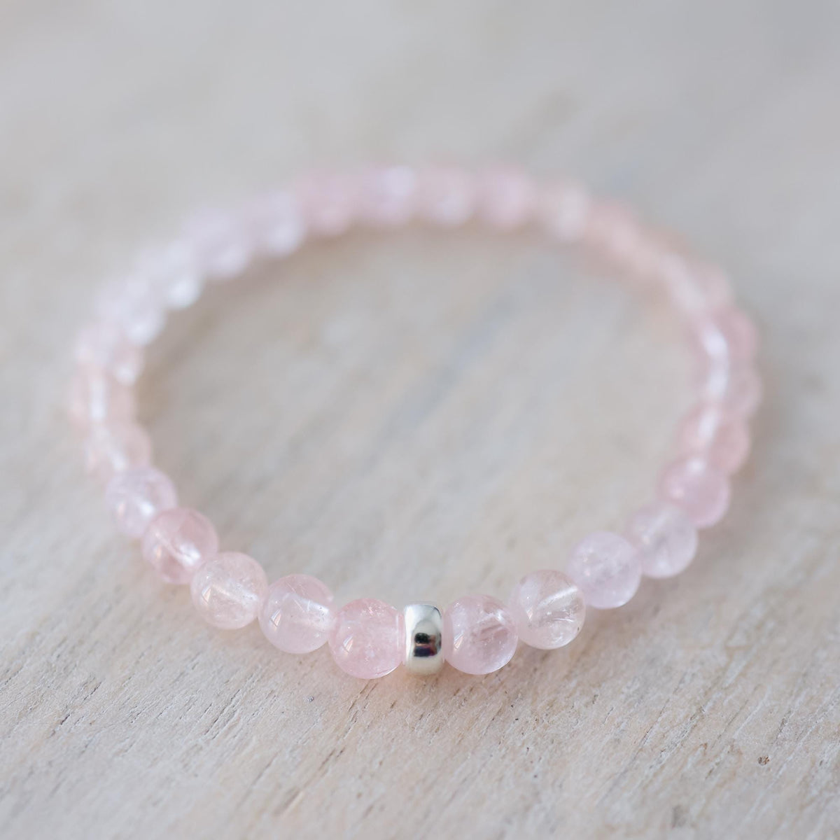 Pink Morganite 6mm gemstone from Earthly Abundance Jewelry, showcasing a smooth, faceted pink pink stone on a white background.