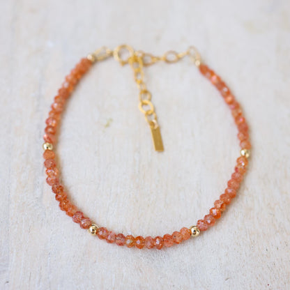 Sunset Crush Sunstone bracelet featuring orange and red sunstone beads on a stretch cord, by Earthly Abundance.