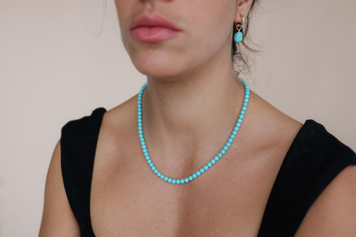 Sleeping Beauty turquoise necklace with 5.5mm beads in solid 14K gold chain, featuring a vibrant blue turquoise pendant.